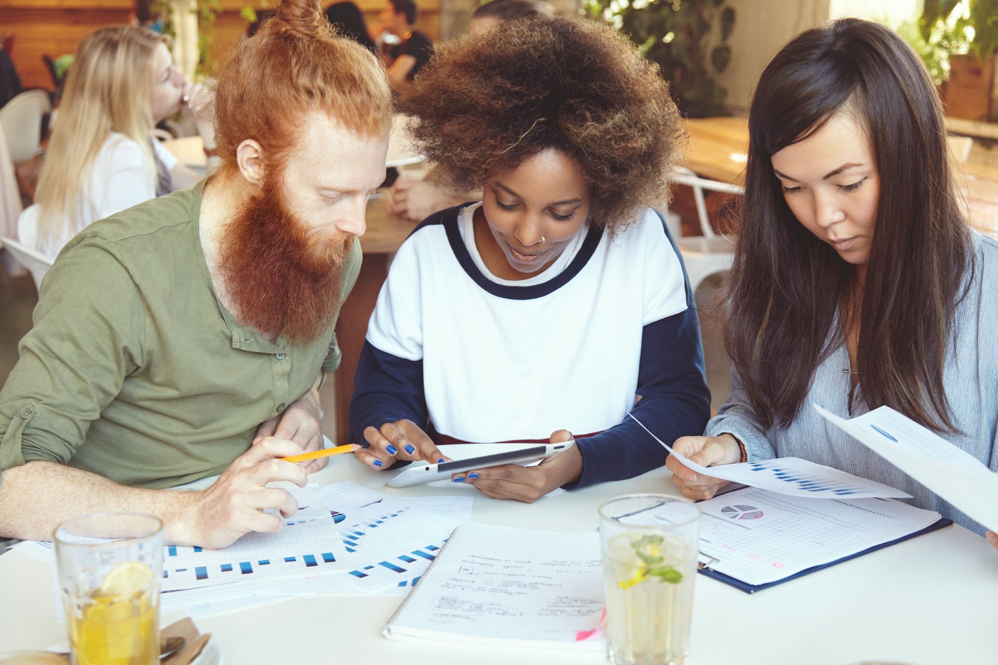 team-marketing-experts-developing-business-strategy-cafe-african-woman-presenting-business-plan-her-partner-with-red-beard-digital-tablet-while-their-asian-colleagu-1